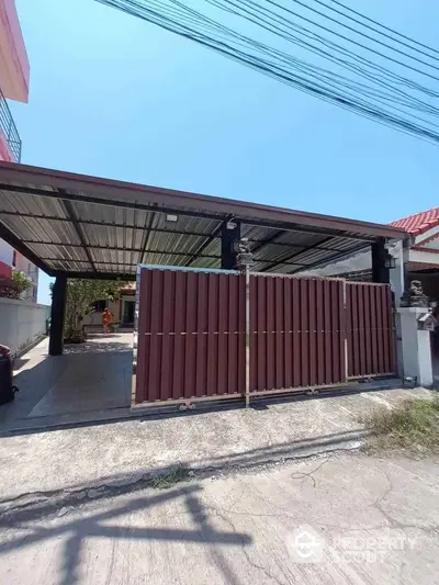 Spacious covered parking area with modern gate in residential property