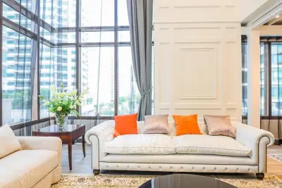 Luxurious living room with elegant sofa and panoramic city view.