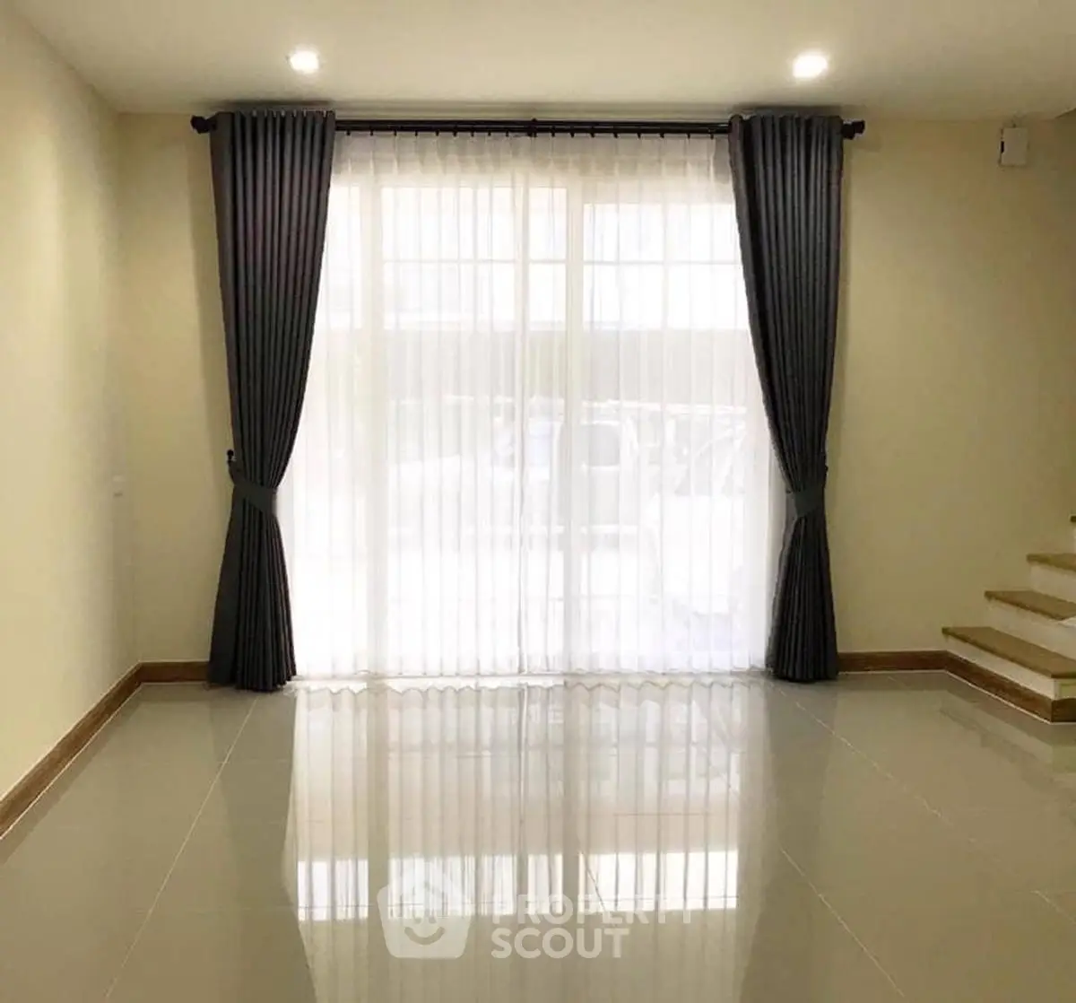 Spacious living room with elegant curtains and glossy tile flooring