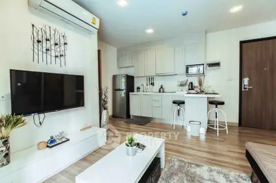 Modern living room with open kitchen, stylish decor, and cozy ambiance in a contemporary apartment.