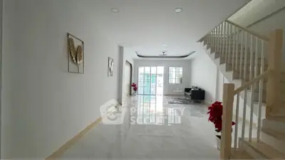 Spacious modern living room with elegant staircase and natural light