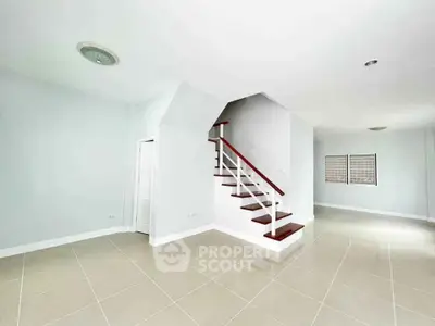 Spacious modern interior with elegant staircase and tiled flooring