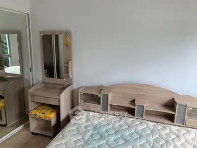 Spacious bedroom with modern wooden furniture and large mirror closet doors.