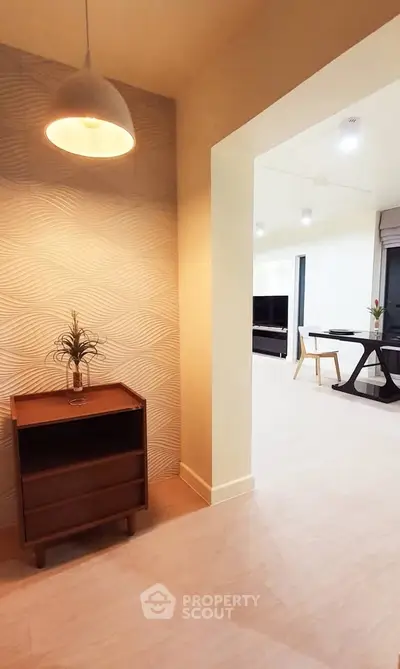 Modern interior hallway leading to a stylish living room with contemporary furniture and decor.