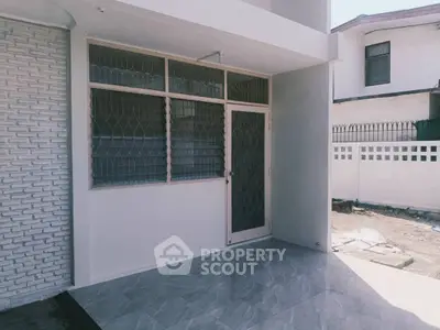 Modern exterior with sleek tiled entrance and secure window grills