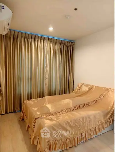Cozy bedroom with elegant golden curtains and matching bedspread, perfect for relaxation.