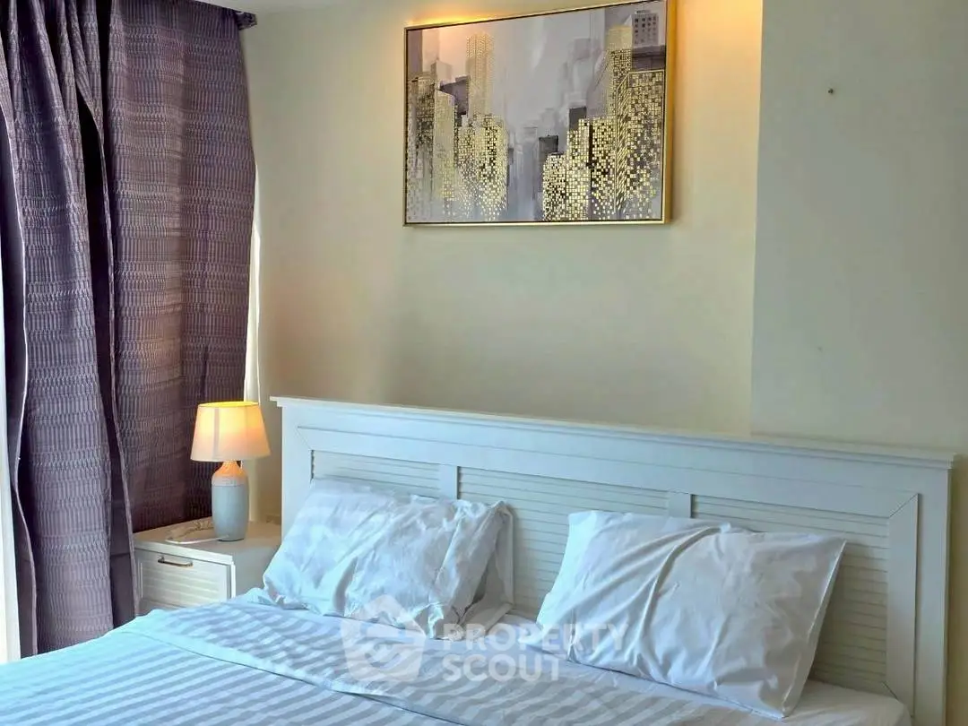 Cozy bedroom with elegant decor and cityscape artwork, perfect for relaxation.