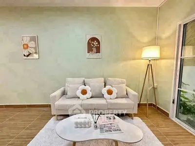 Charming living room with cozy sofa, stylish decor, and warm lighting, perfect for relaxation.