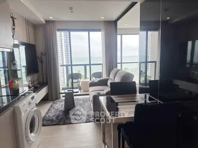 Modern living room with ocean view, featuring cozy seating and a washing machine, perfect for urban living.