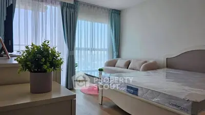 Bright and airy bedroom with large window and modern furnishings, perfect for relaxation.