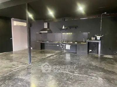 Spacious industrial-style kitchen with open layout and modern fixtures.