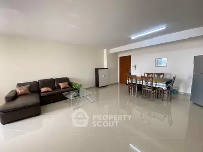 Spacious modern living room with sleek furniture and dining area, perfect for family gatherings.