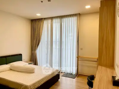 Modern bedroom with large window and stylish furnishings
