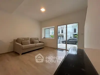 Spacious living room with modern sofa and large window offering natural light.