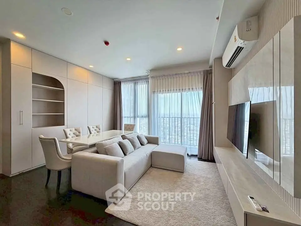 Modern living room with elegant furniture and large windows offering city views.