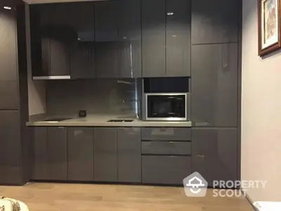 Modern kitchen with sleek dark cabinets and built-in microwave