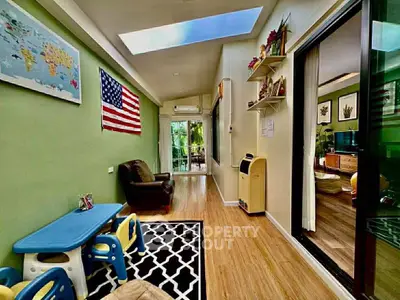 Charming living room with skylight and American flag decor, featuring a cozy seating area and children's play table.