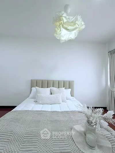Elegant bedroom with modern decor and cozy bedding in a bright, minimalist style.