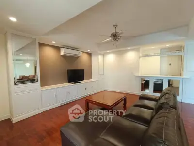 Spacious living room with elegant leather sofa and built-in entertainment center.
