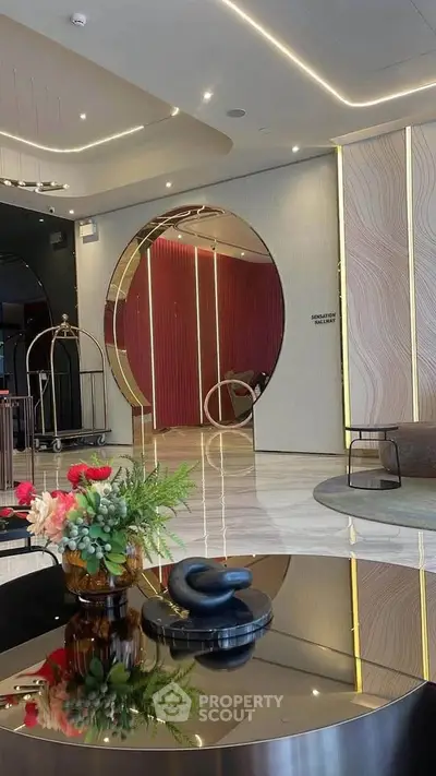 Luxurious modern lobby with elegant decor and circular mirror feature.