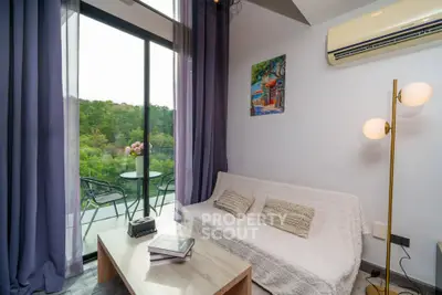Charming living room with balcony view, cozy sofa, and elegant decor in modern apartment.