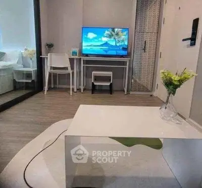 Modern living room with sleek furniture and a flat-screen TV, perfect for cozy relaxation.