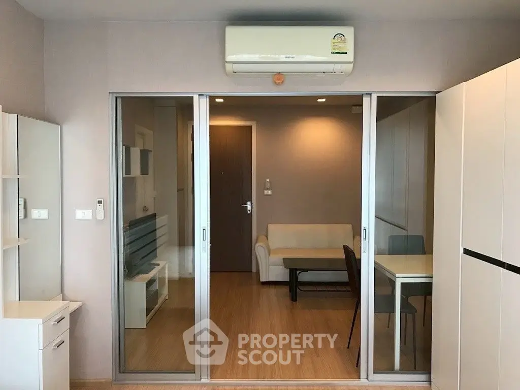 Modern living room with sliding glass doors and air conditioning in a stylish apartment.