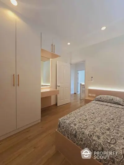 Modern bedroom with elegant wooden flooring and built-in wardrobe