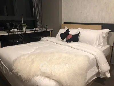 Cozy bedroom with modern decor and plush bedding, featuring a stylish workspace by the window.