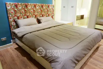 Charming bedroom with floral headboard and cozy bedding in modern apartment.