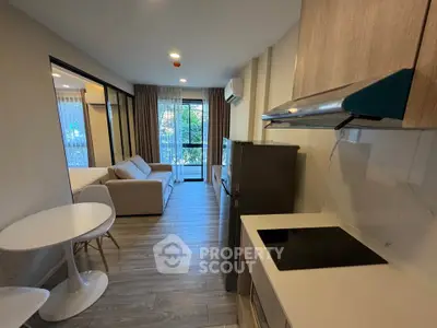 Modern open-plan living room and kitchen with balcony view