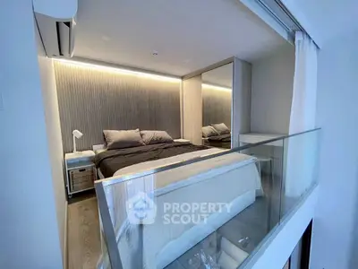 Modern bedroom with glass railing and stylish lighting