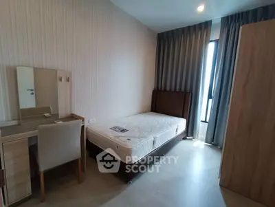 Cozy bedroom with natural light, featuring a single bed, wardrobe, and study desk.