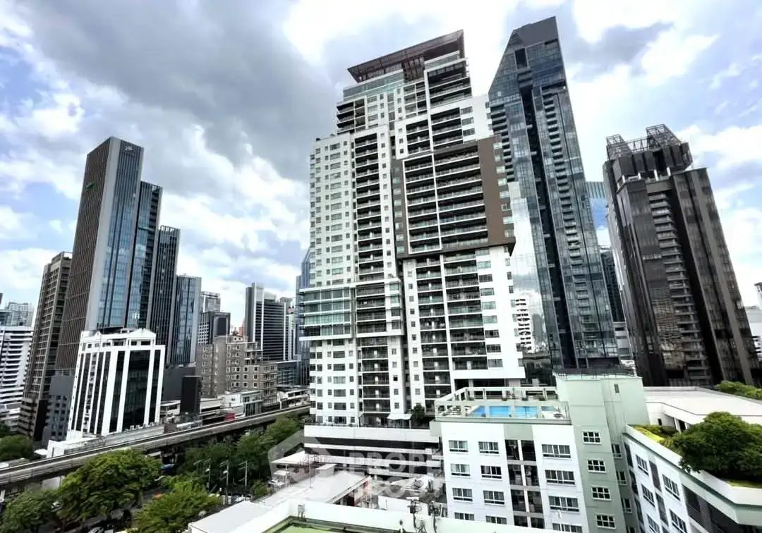Stunning cityscape view of modern high-rise buildings with lush greenery and dramatic sky.