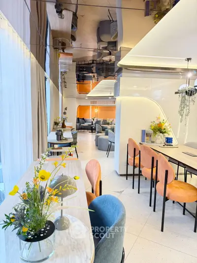 Modern open-plan living and dining area with stylish decor and vibrant seating.