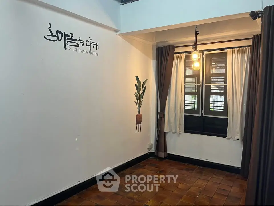 Charming interior space with rustic flooring and modern lighting, perfect for cozy living.