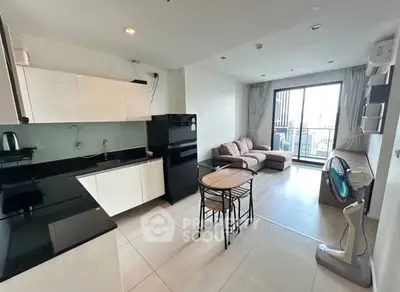 Modern open-plan living room with kitchen and balcony view