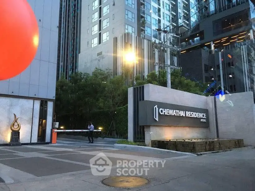 Modern urban residence entrance with sleek design and high-rise buildings in the background.