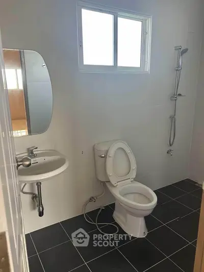 Modern bathroom with sleek fixtures and natural light from window.