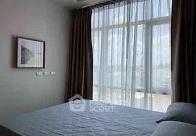 Bright bedroom with large window and elegant curtains, perfect for natural light lovers.