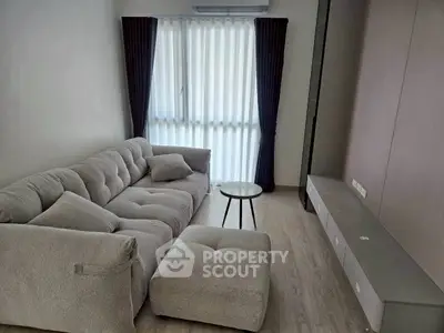 Modern living room with plush gray sofa and natural light
