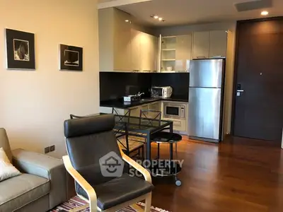 Modern open-layout kitchen and living area with sleek appliances and stylish furniture.