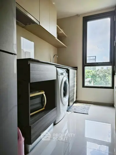 Modern kitchen with washing machine and large window view
