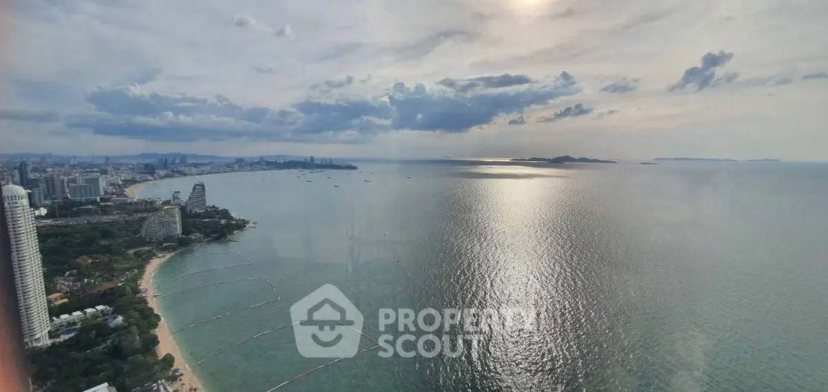 Stunning coastal view from high-rise building overlooking serene ocean and city skyline.