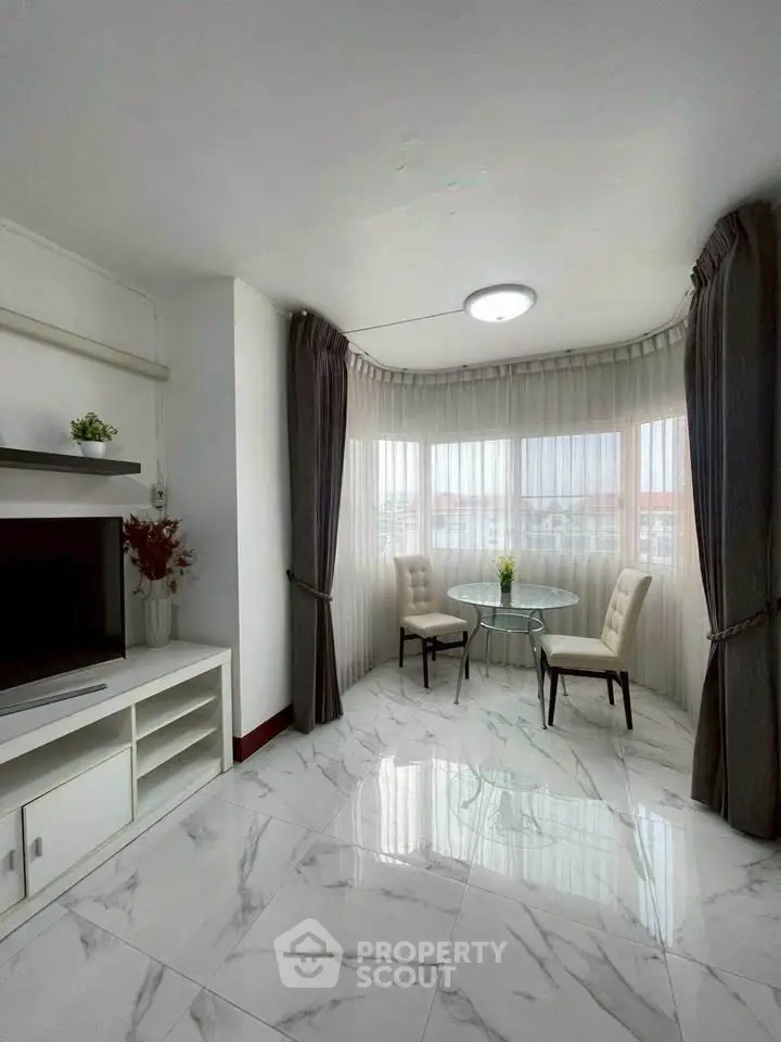 Bright and elegant living room with marble flooring and cozy dining nook.