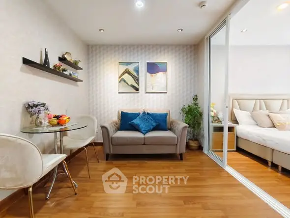 Modern living room with cozy seating and stylish decor adjacent to a bedroom.