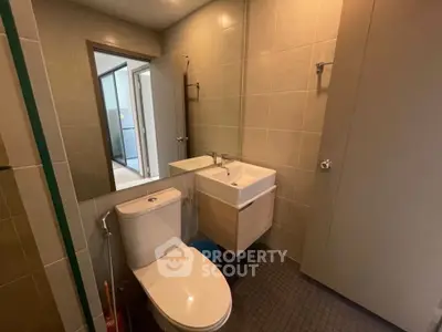Modern bathroom with sleek fixtures and neutral tiles in a contemporary apartment.