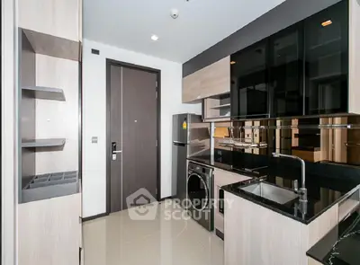 Modern kitchen with sleek black cabinets and built-in appliances in a stylish apartment.