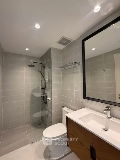 Modern bathroom with sleek design, featuring a glass shower and stylish vanity.