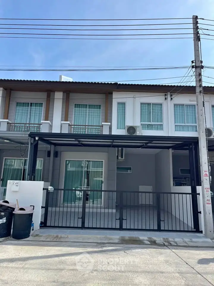 Modern townhouse exterior with gated parking and contemporary design.